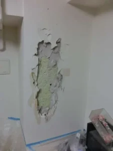 寝室の壁が大きく損傷している様子