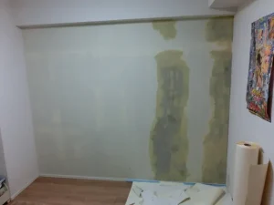 コンクリート下地に壁紙が付いていない部分にパテで補修した状態