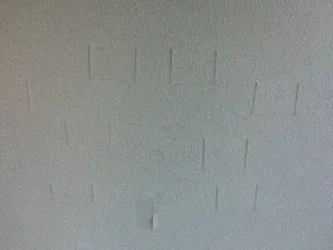 壁紙が剥がれ・欠損した部分を剥がした壁紙を使って部分補修している様子