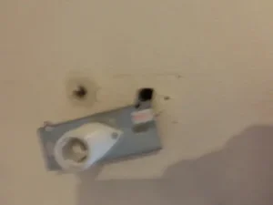 照明器具がアンカーごと外れて、壁に穴が空いている状態
