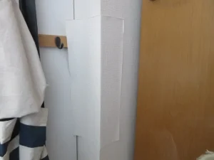 剥がした壁紙を再利用して部分補修している様子