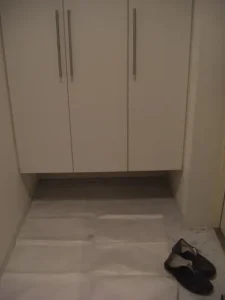 下駄箱の下に補修用の壁紙として剥がせる壁紙がある