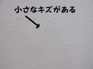 白い壁紙に小さなキズが付いた状態