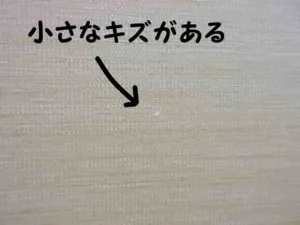 ベージュ系のアクセントクロスに小さなキズがある状態