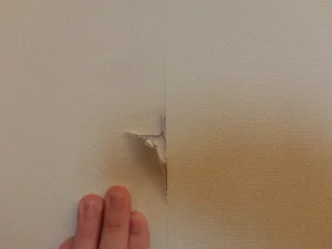 ドアが壁に当たって破損した壁の現状