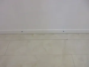 外した木巾木と床材（塩ビタイル）を戻した様子