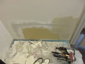 壊れた石膏ボードを部分的に交換して壁を直した様子