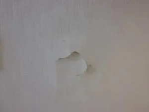 破れた壁紙を再利用して壁紙を補修している様子