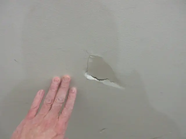 塗装壁に穴が空いた様子。凹んで穴が空いています。