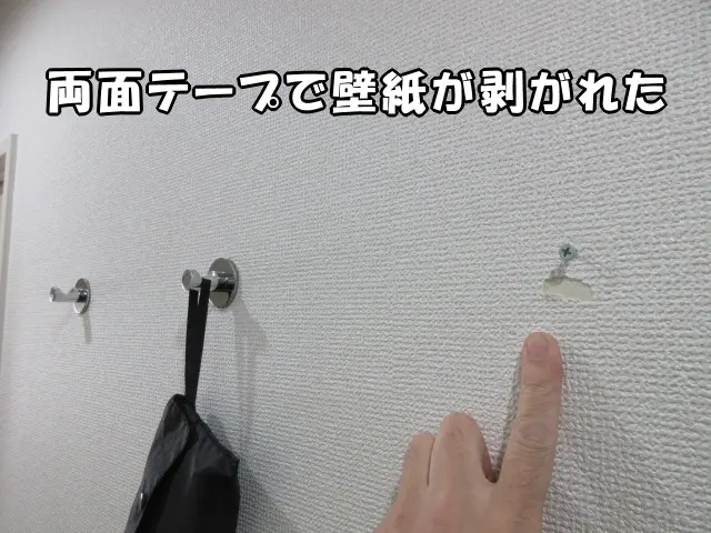 両面テープで壁にフックが取り付けてあり、無理に外して壁紙が剥がれている様子