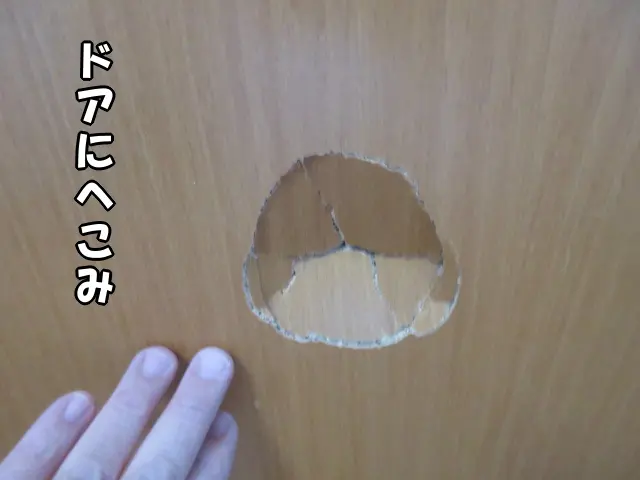 部屋のドアに大きな凹がある様子